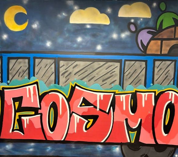 Een met de hand geschilderde muurschildering bij Cosmo Zorg: de naam COSMO in graffitiletters onder een sterrenhemel met maan.